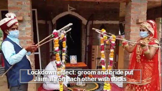 Lockdown effect- groom and bride put Jaimala on each other with sticks