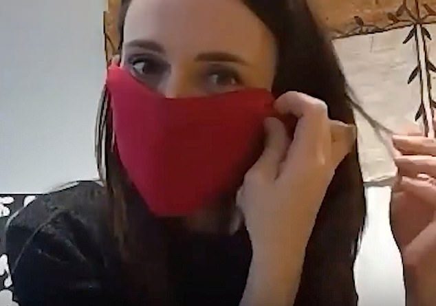 New Zealand Prime Minister Jacinda Ardern demonstrates how she makes an improvised face mask during a video meeting with local community health leaders