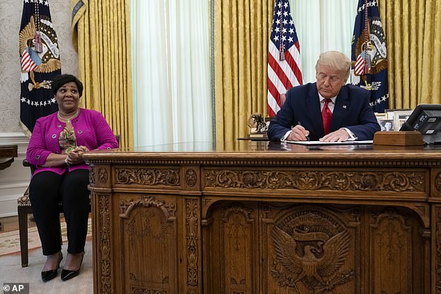 Alice Johnson (left) watches as President Trump (right) grants her a full pardon in the Oval Office Friday, a day after she addressed the Republican National Convention