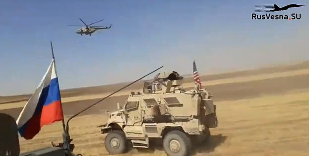 High-speed confrontation: This is the moment before the Russian vehicle from which the video footage came hits the U.S. armored vehicle as the two patrols move fast across a field in northern Syria with a Russian military helicopter flying low overhead