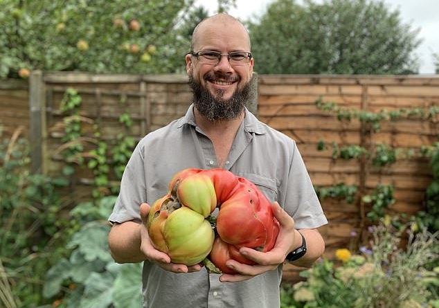 Douglas Smith’s (pictured with his tomato) efforts paid off when he broke the record to grow Britain’s biggest tomato