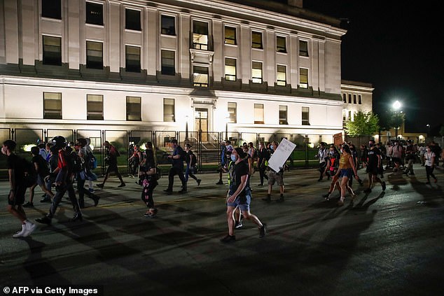 Protesters gathered near the courthouse in Kenosha for the fourth night in a row, defying a 7pm curfew to denounce the police shooting of black man Jacob Blake. Peaceful marchers pictured on Wednesday evening walking in Kenosha