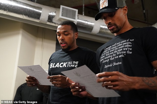 Sterling Brown and George Hill of the Milwaukee Bucks reads a statement to the media