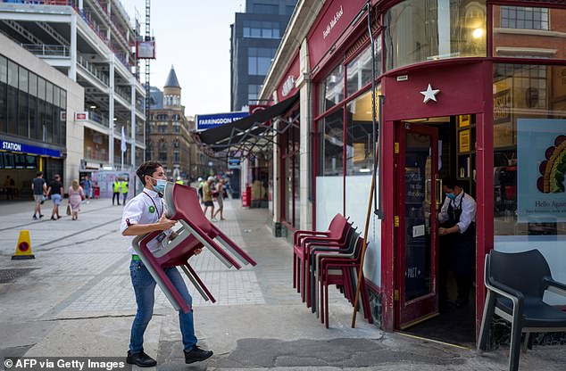 A worker wearing a face covering, puts away chairs as they prepare to close a Pret-a-Manger store in London on August 12 in London