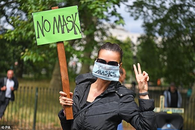 People who refuse to wear a face mask or comply with social distancing are more likely to have sociopath tendencies, a study has found. Pictured: A woman holds a sign and wears a mask as she protests in Hyde Park in central London on July 19