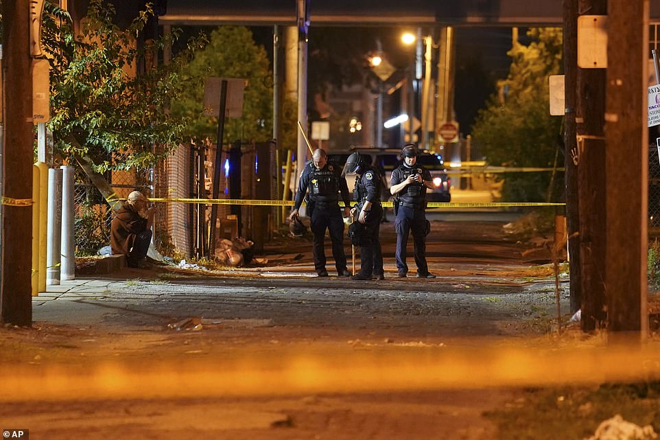 Police survey an area where two officers were shot in Louisville on Wednesday night