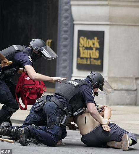 Officers pull a man to the ground as they detain him during a protest on Wednesday afternoon in Louisville