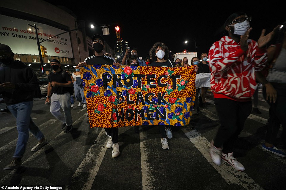 Protesters carry a banner reading 'Protect black women' as they walk through the streets of the Big Apple