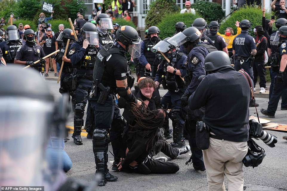 Two protesters are thrown to the ground by police during a march in downtown Louisville on Wednesday afternoon
