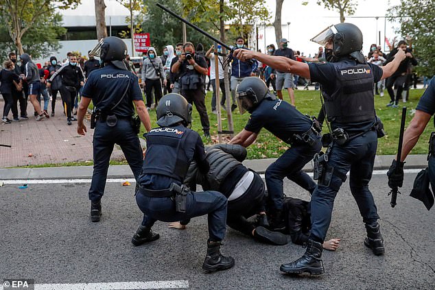 Police officers try to hold down a protester in Madrid, Spain, after hundreds take to the streets to demand better health care