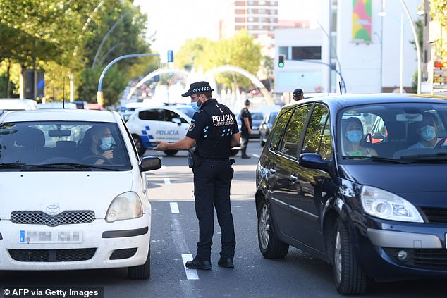 Local police officers control people's movement in a traffic checkpoint in the under partial lockdown town of Fuenlabrada, in Madrid region, on September 22