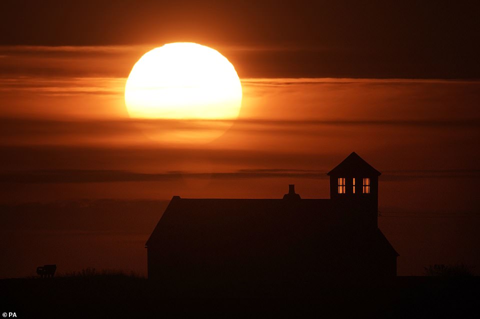 The sun rises behind the Watch House Museum at Seaton Sluice in Northumberland today