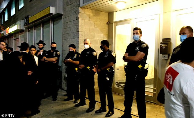 Masked police officers at the scene where hundreds of Hasidic men gathered on Sunday night