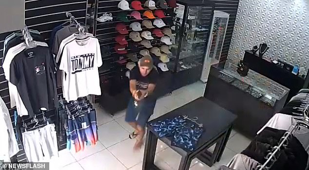 One robber fires a single shot at the owner, shattering a display case over his left shoulder (pictured to the right), before the owner fires multiple shots in response