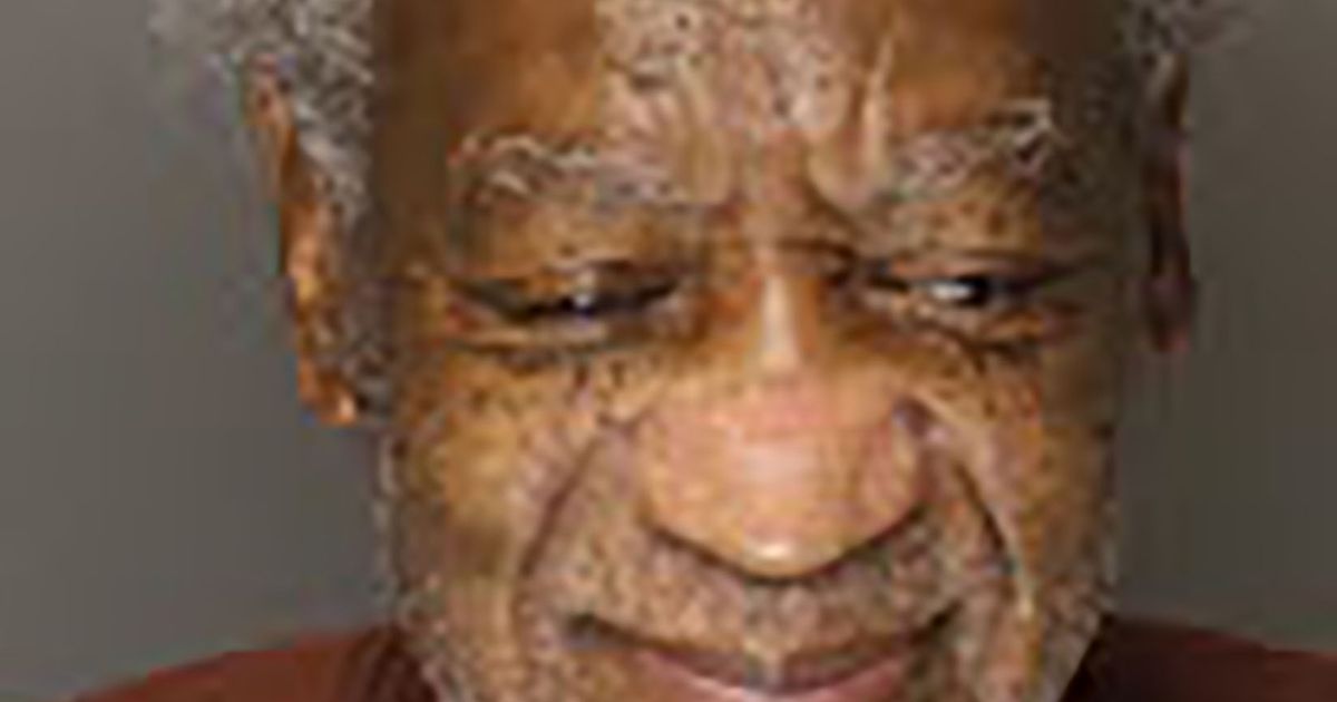 Shamed Bill Cosby looks dishevelled with long hair as he smirks in new mug shot