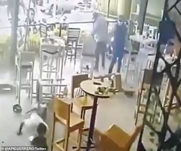Surveillance camera from a bar in Guerrero, Mexico, captured the tragic moment two men (pictured standing) walked up to a table to seven patrons and opened fired. The October 17 shooting left three people dead and four others with gunshot wounds