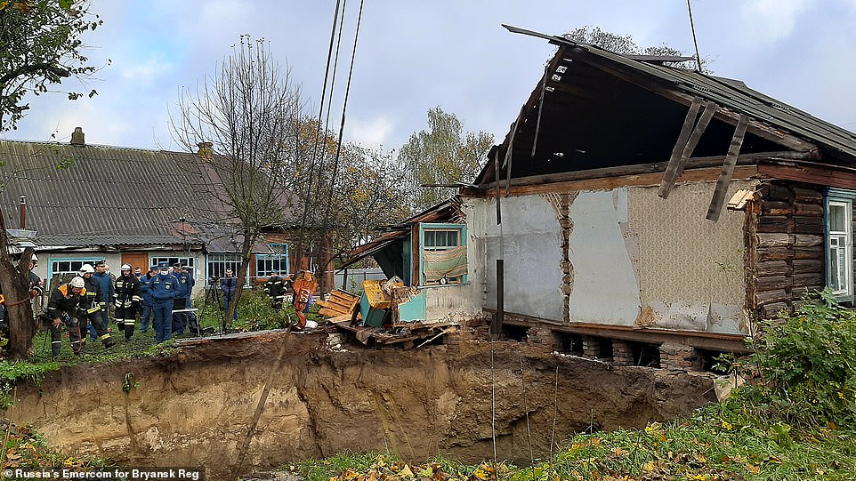 House sucked into sinkhole in Russia as rescuers search debris for elderly woman who was inside 