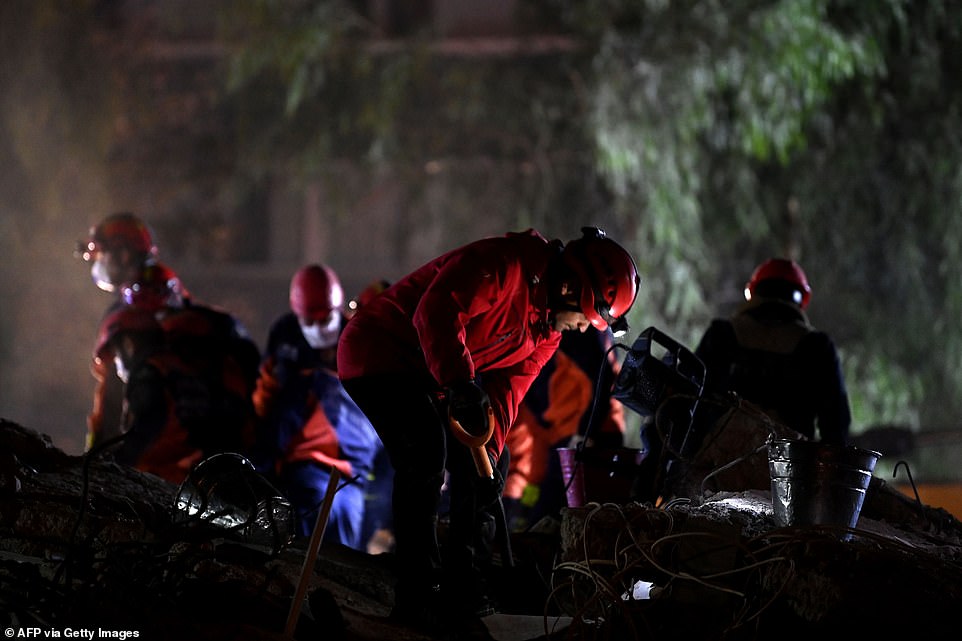 Search and rescue teams look for victims at the site of a collapsed building in Izmir today after the powerful earthquake struck