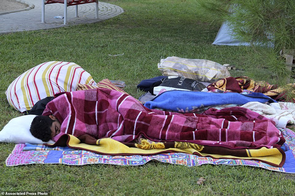 A man sleeps outdoors on Sunday after an eathquake destroyed homes in Izmir, Turkey