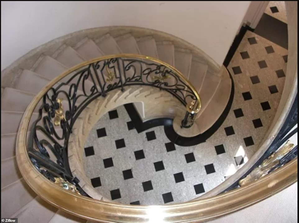 Pictured: Opulent white and black marble floors led to a winding staircase that is topped with a cheetah-print rug