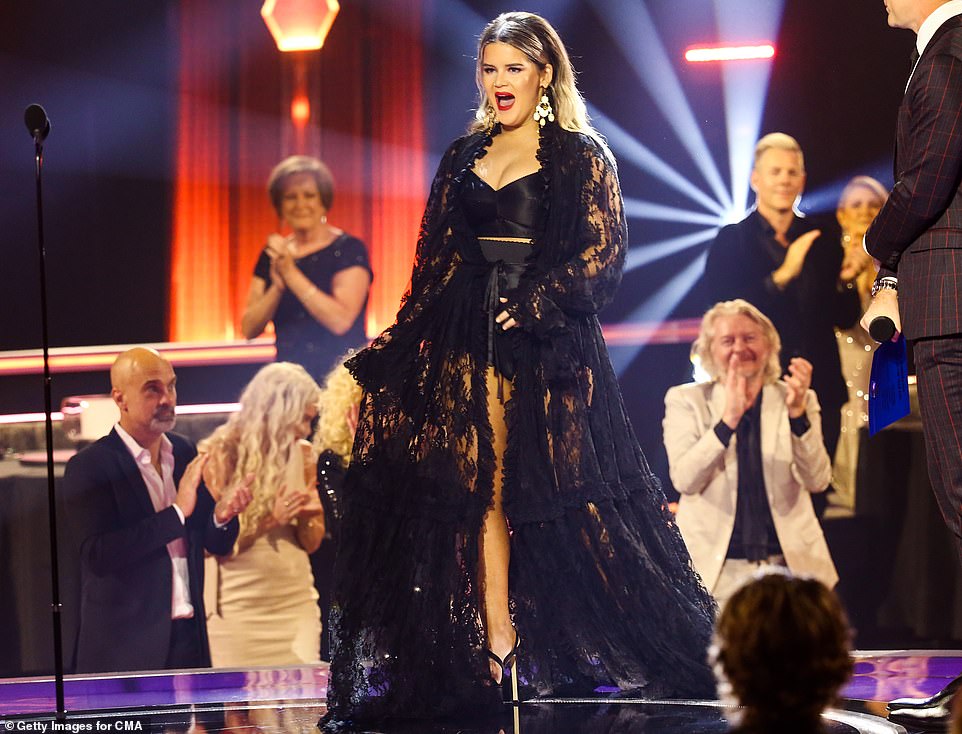 Back in black: She took to the stage in a stunning black lace floor-length robe over black silk undergarments, as she accepted the award from presenter Bobby Bones