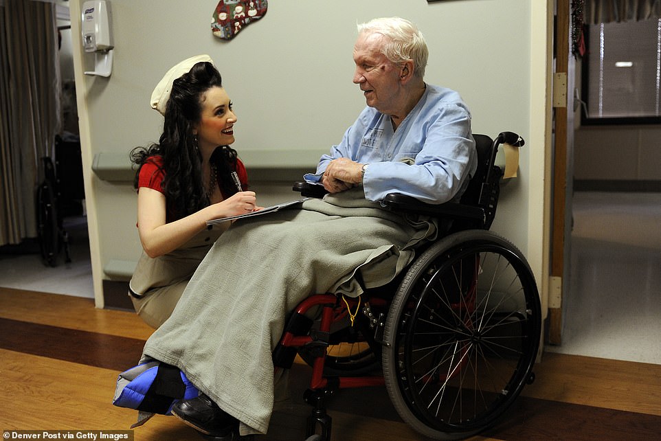 Elise is pictured signing a calendar for former Navy Lt. Bill Wood during her visit in 2011.  This year, amid the pandemic, the organization will be shipping care packages to hospitalized veterans as well as deployed troops