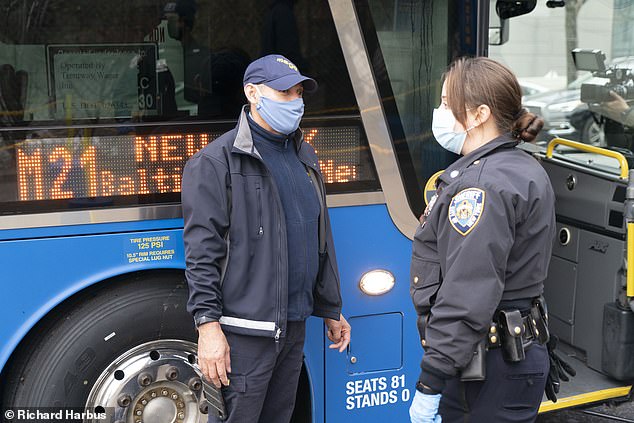 An officer stops a traveler arriving to New York on Wednesday at a Covid checkpoint