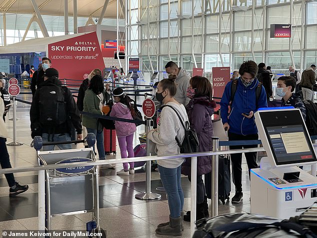 Pictured, travelers in JFK on Thanksgiving Eve. Millions are still expected to travel