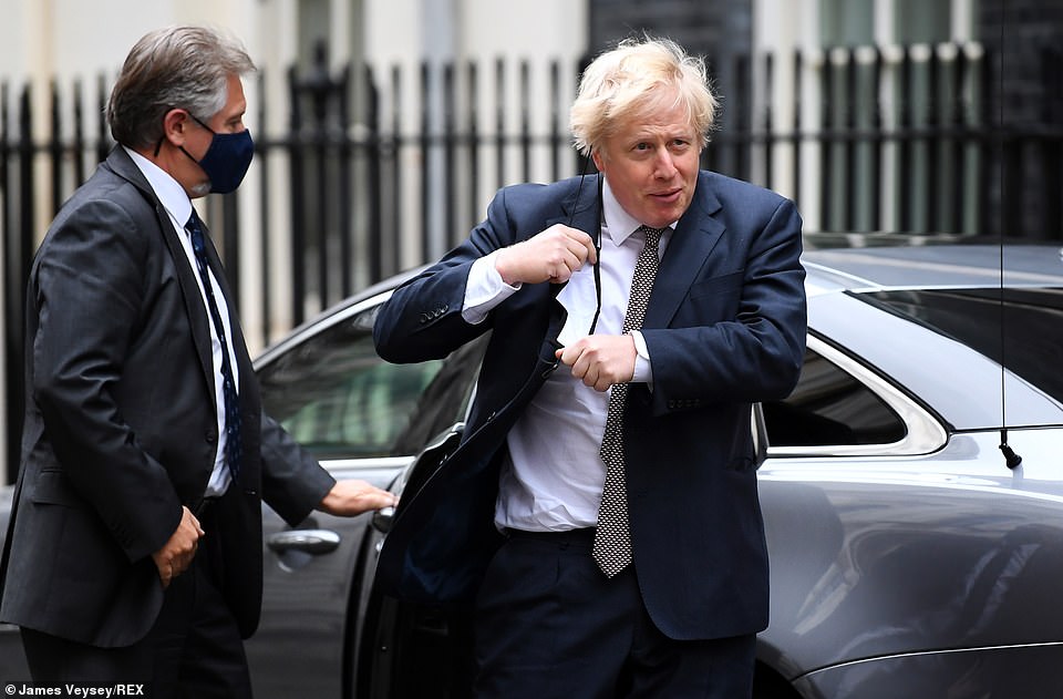 The PM wrestled with his mask as he exited his official car on returning from the Commons to No10 today