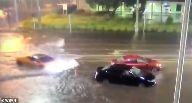 Moment sports car driver plows through Eta flood waters in Miami
