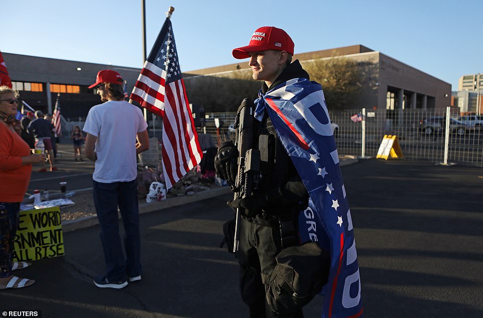 Trump fans wearing MAGA hats and holding rifles protest outside election center