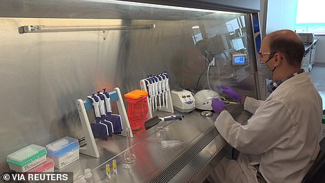 A technician inspects vials of coronavirus disease (COVID-19) vaccine candidate BNT162b2 at a Pfizer manufacturing site in manufacturing site in St. Louis, Missouri