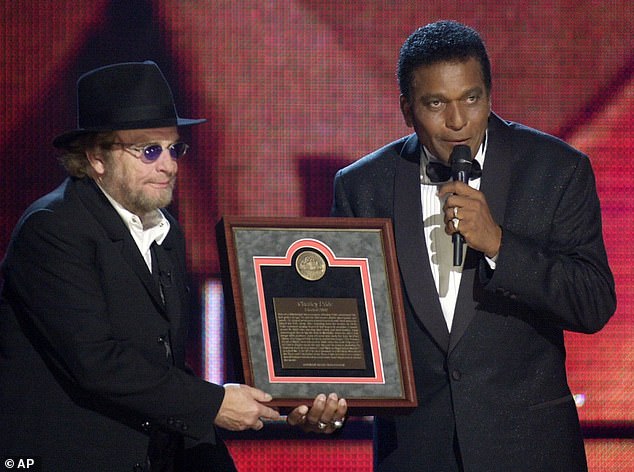 Pride receives his Country Music Hall of Fame plaque from Merle Haggard in October 2000