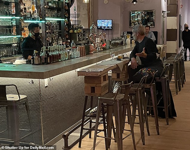 A diner sits by the bar on Sunday night before New York City's indoor dining is shut down