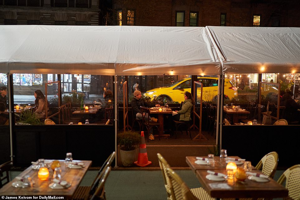 Diners eating under the outdoor dining set-up at Osteria Cotta in Manhattan on Tuesday night