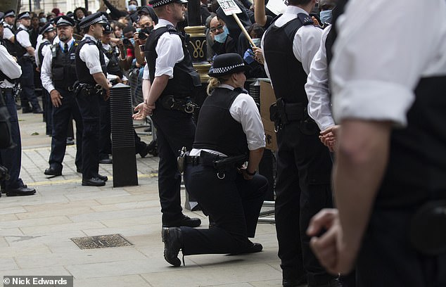 Pictured: A police officer goes to one knee in front of Black Lives Matter protesters in London on June 3, 2020