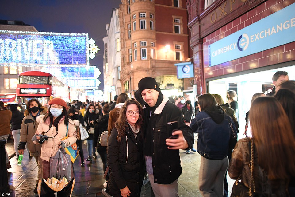 Two people paused for a photograph while shopping on London's Oxford Street on the last Saturday before Christmas
