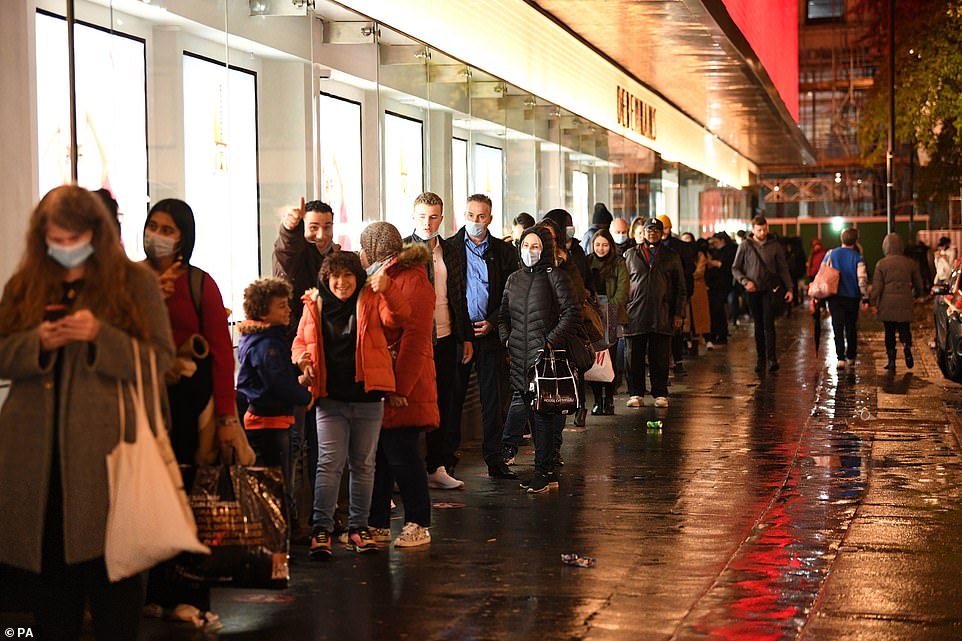 Pictured: Shoppers queue outside a shop in Oxford Street on Saturday night ahead of the introduction of Tier 4, announced by Boris Johnson on Saturday evening in an attempt to curb the spread of the coronavirus