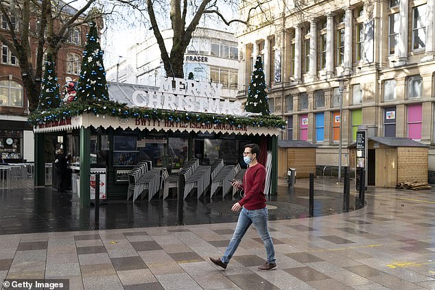 A man walked past a Cardiff cafe with a Merry Christmas sign on December 20 after all non-essential shops were forced to shut