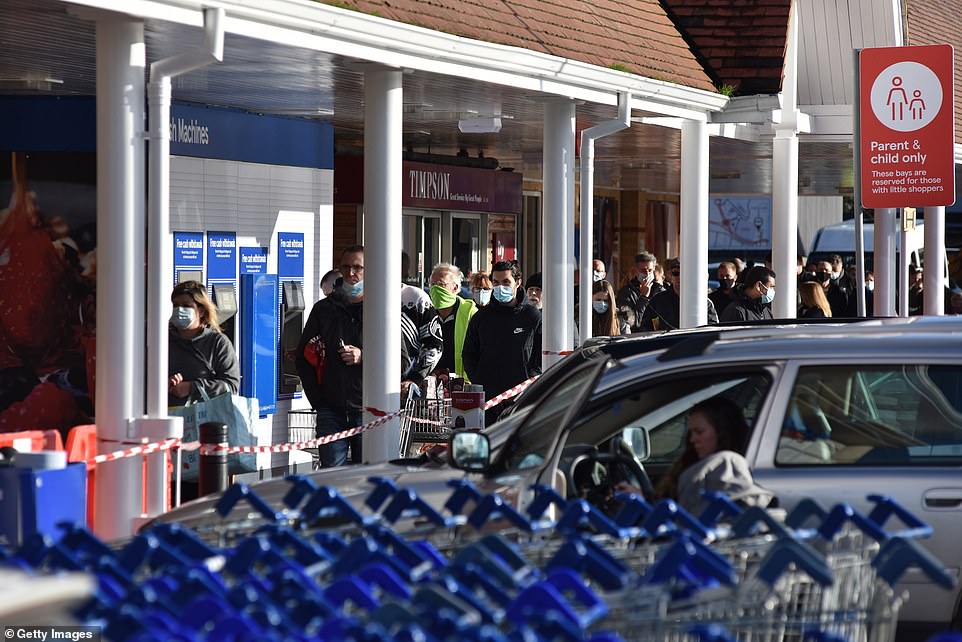People queued after it was announced all non essential shops and retailers will close in areas including London, Kent, Essex and Bedfordshire. Pictured: Tesco supermarket in Essex