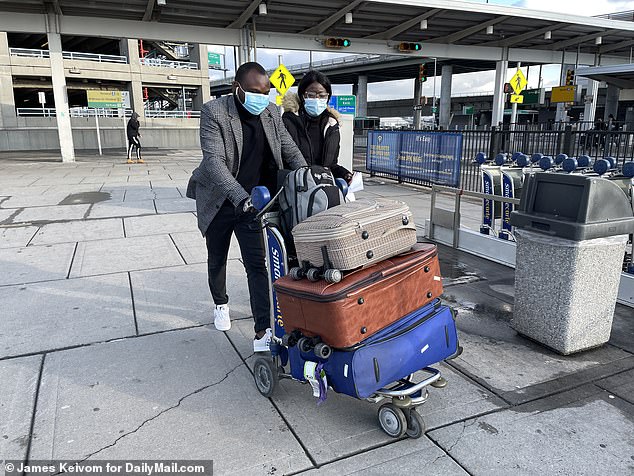 Oore Adegbite, right, arrives at JFK International Airport after flying from London on Tuesday