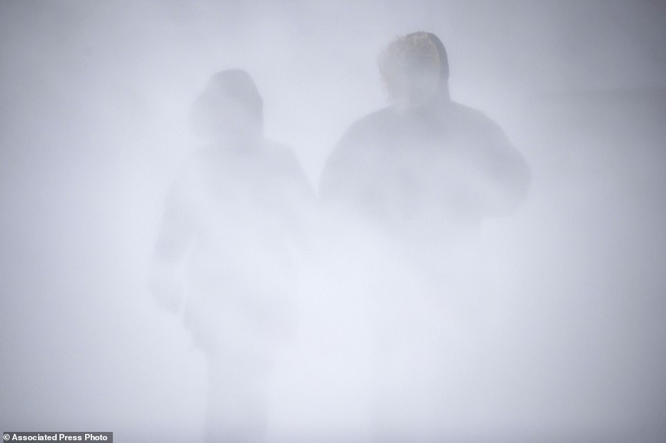 Two residents of Duluth, Minnesota are barely visible as they move through the snow on Wednesday