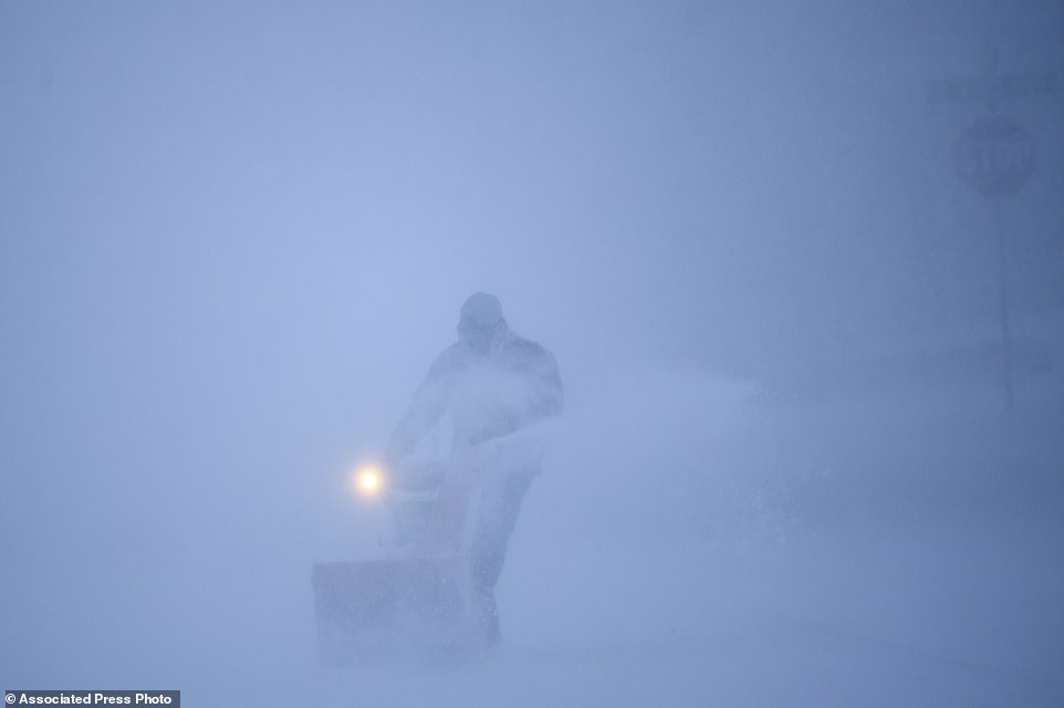A resident uses a snow blower to clear his driveway during the storm in Robbinsdale, Minnesota on Wednesday