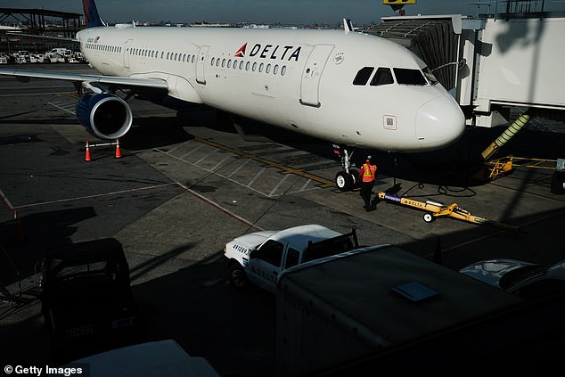 Two passengers escaped a Delta airplane down a slide with their dog before it took off from LaGuardia Airport in New York on Monday after one said he was suffering with post-traumatic stress disorder. Pictured: A Delta plane sits on the tarmac at the airport