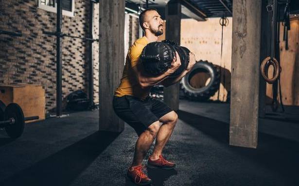 Workout with a sandbag to build muscles and gain strength
