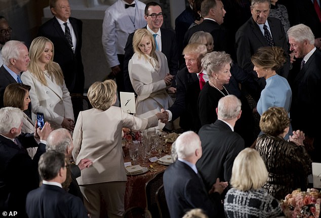 President Trump shakes hands with Hillary Clinton as he and Melania arrive at his luncheon in January 2017 - this year's presidential inauguration luncheon has been canceled due to COVID