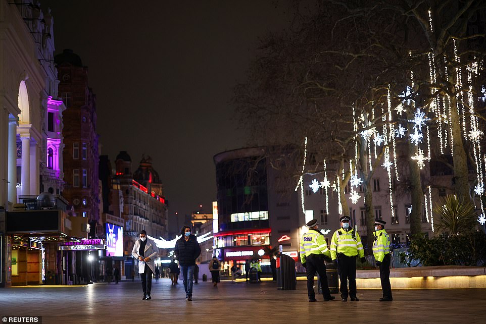 LONDON: A trio of police officers keep watch over Leicester Square this evening, with two pedestrians seen walking past. The Government hopes eople will stick to Tier 4 rules and celebrate New Year's Eve at home