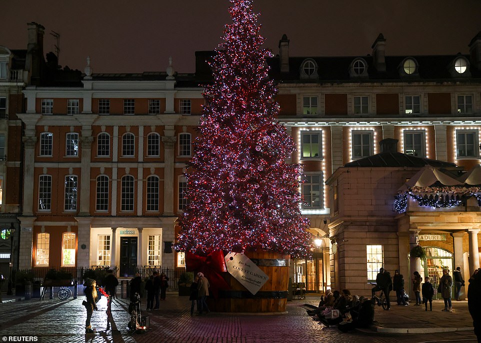 LONDON: A few people stand around a large Christmas tree in Covent Garden, central London, as thousands prepare to celebrate seeing the back of 2020 from their own homes, rather than out partying or enjoying normal celebrations