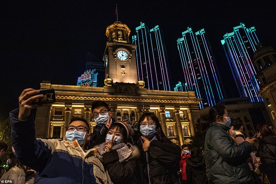 WUHAN: Partygoers posed for a selfie in front of buildings lit up in bright colours. Wuhan had a more-normal New Year's Eve than many others across the globe