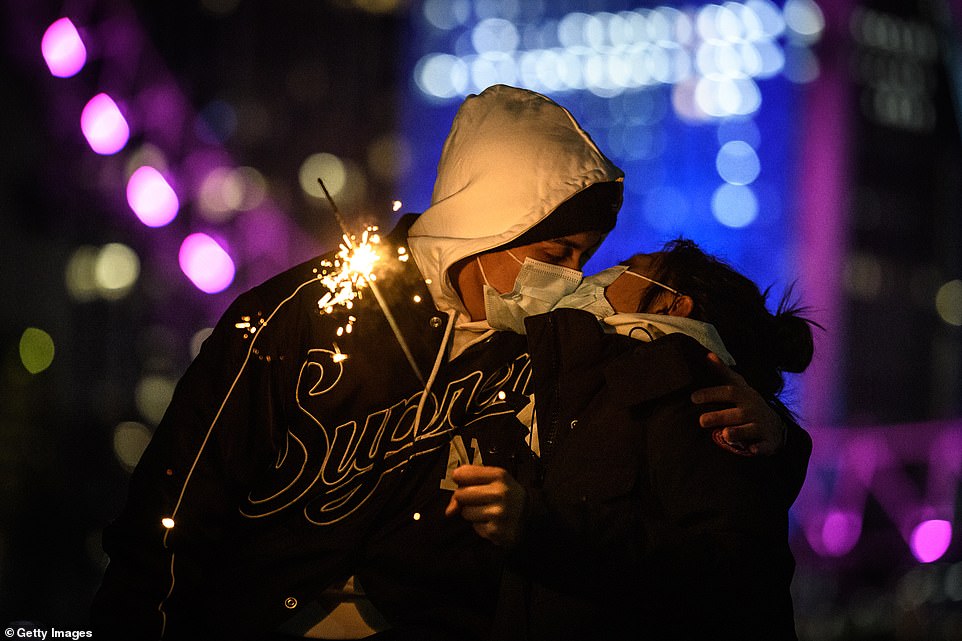 LONDON: A mask-wearing couple kiss while holding a sparkler in front of the London Eye. The annual firework display will not go ahead this year due to coronavirus